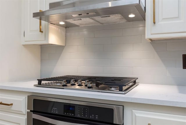 kitchen with white cabinets, backsplash, wall chimney range hood, and stainless steel appliances