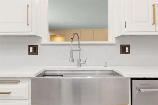 kitchen featuring decorative backsplash, white cabinetry, and sink