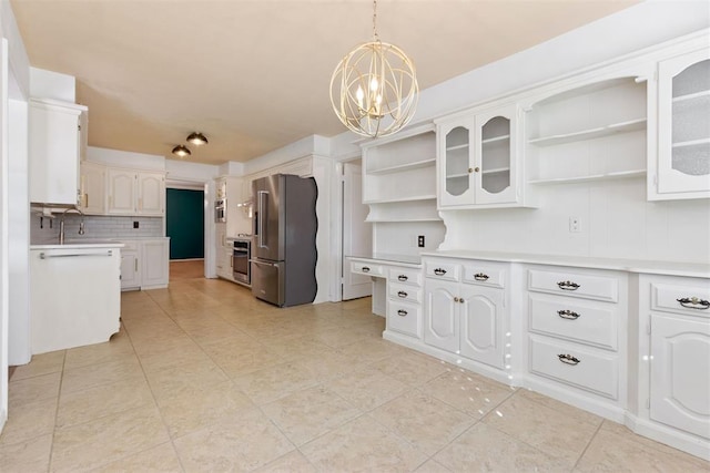 kitchen with tasteful backsplash, a chandelier, pendant lighting, high end fridge, and white cabinets