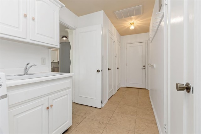 interior space featuring white cabinetry, sink, and light tile patterned floors