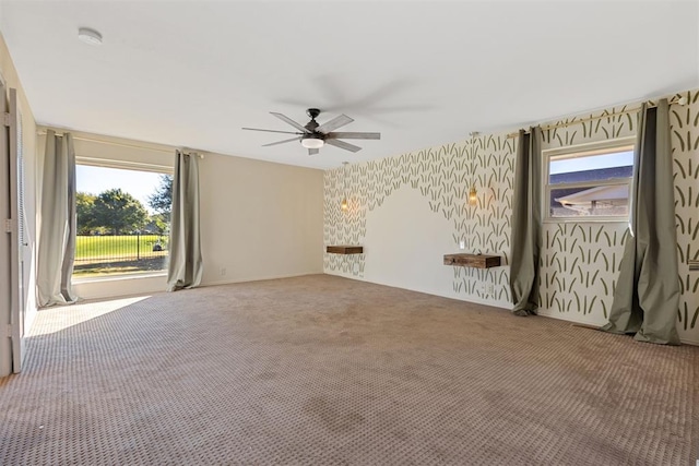 carpeted empty room featuring plenty of natural light and ceiling fan