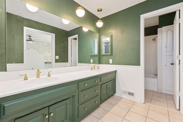 bathroom with tile patterned flooring, ceiling fan, tiled shower / bath, and vanity