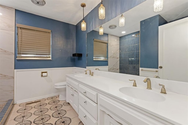 bathroom featuring tiled shower, vanity, tile patterned floors, and toilet