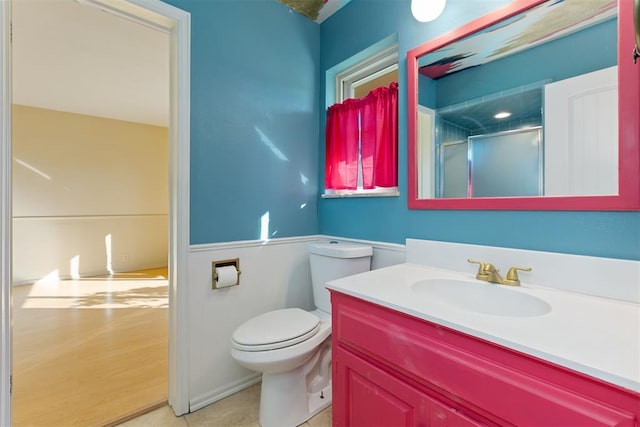 bathroom with vanity, toilet, and a shower with shower door