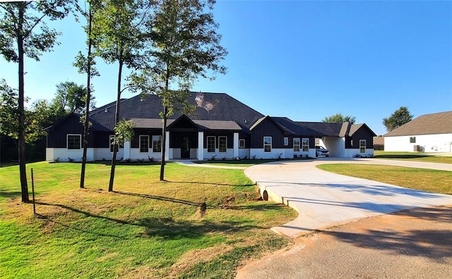 1308 W Harvard Way, Mustang, OK 73064 - view of front of home with curved driveway, a front lawn, and board and batten siding