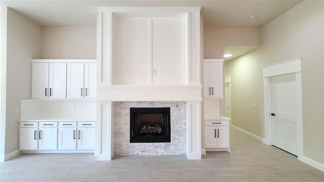 1308 W Harvard Way, Mustang, OK 73064 - unfurnished living room featuring a fireplace, light wood-type flooring, and baseboards