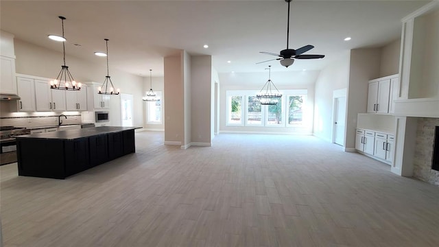 1308 W Harvard Way, Mustang, OK 73064 - kitchen featuring gas stove, open floor plan, tasteful backsplash, a ceiling fan, and a sink
