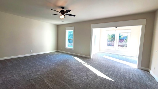 unfurnished room with dark colored carpet and ceiling fan