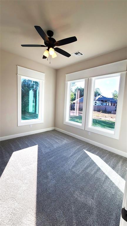 1308 W Harvard Way, Mustang, OK 73064 - empty room featuring dark colored carpet, baseboards, and a ceiling fan