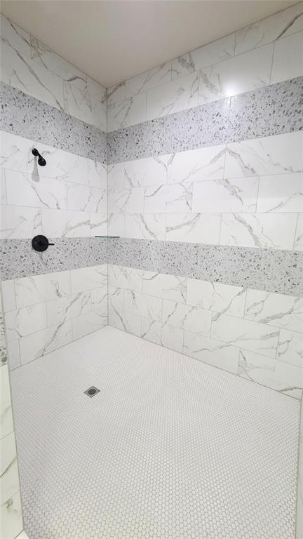 interior details featuring tiled shower