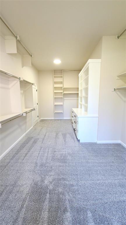 1308 W Harvard Way, Mustang, OK 73064 - walk in closet featuring light colored carpet