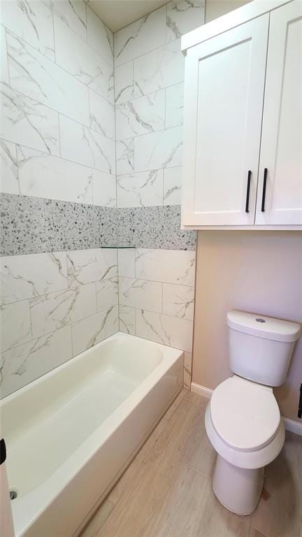 bathroom with toilet, washtub / shower combination, and wood-type flooring