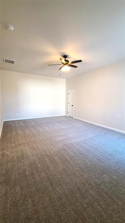 carpeted spare room with ceiling fan