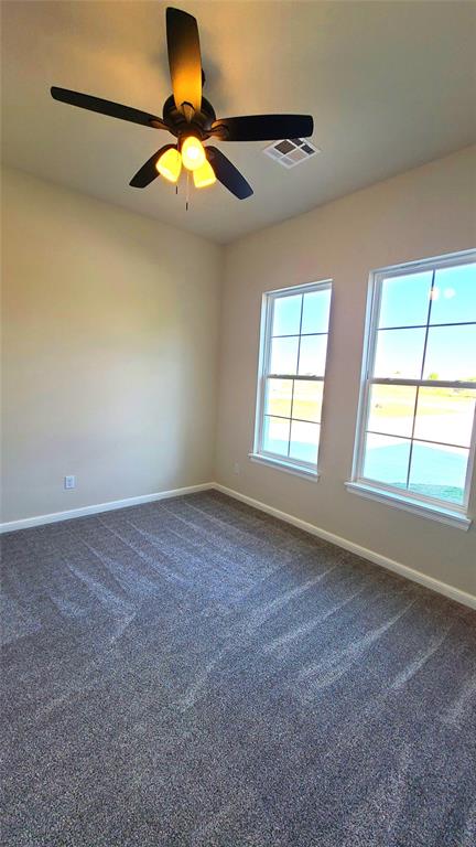 carpeted spare room featuring ceiling fan