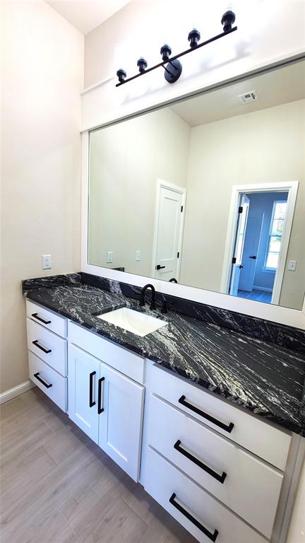 1308 W Harvard Way, Mustang, OK 73064 - bathroom with wood finished floors, vanity, and baseboards