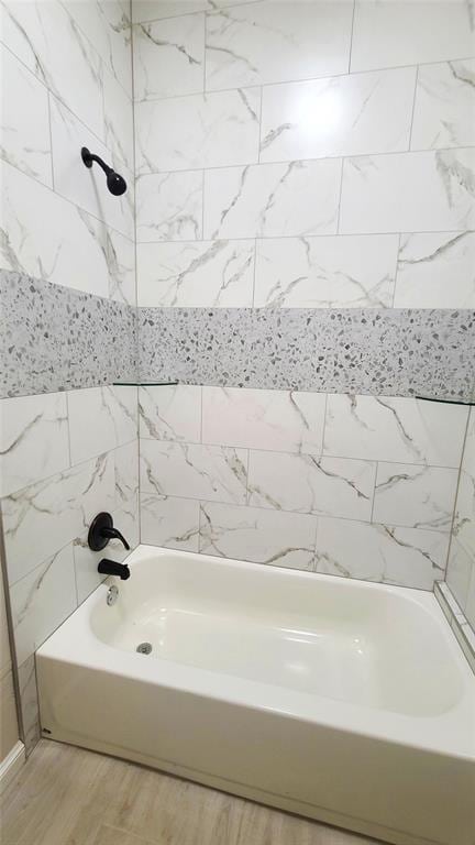 bathroom with hardwood / wood-style floors and tiled shower / bath combo