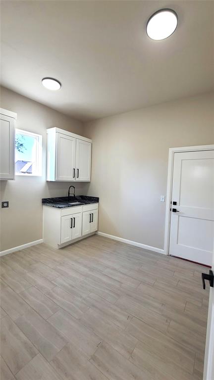 1308 W Harvard Way, Mustang, OK 73064 - washroom featuring baseboards, a sink, and light wood-style flooring