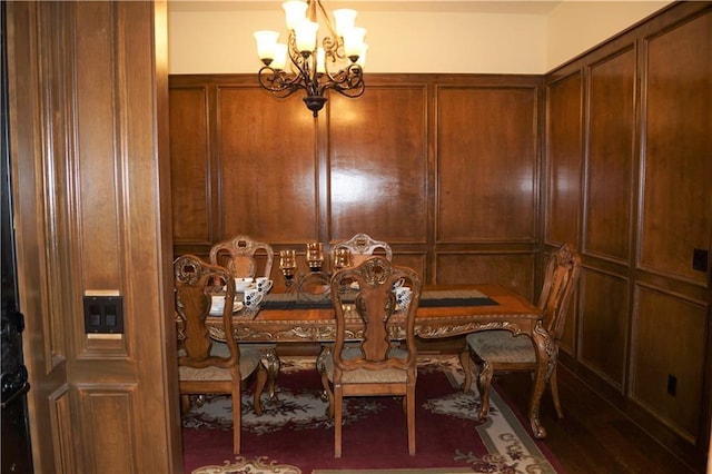 dining area featuring dark hardwood / wood-style floors and an inviting chandelier