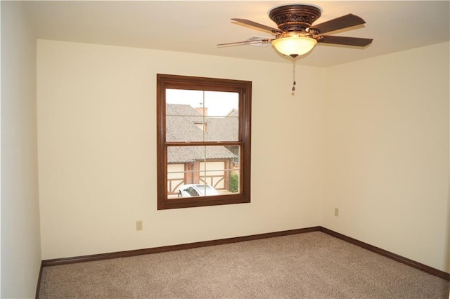 carpeted spare room featuring ceiling fan