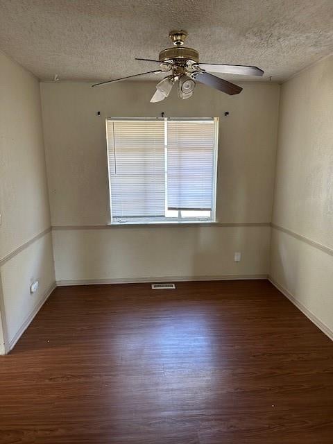 spare room with ceiling fan, dark hardwood / wood-style flooring, and a textured ceiling