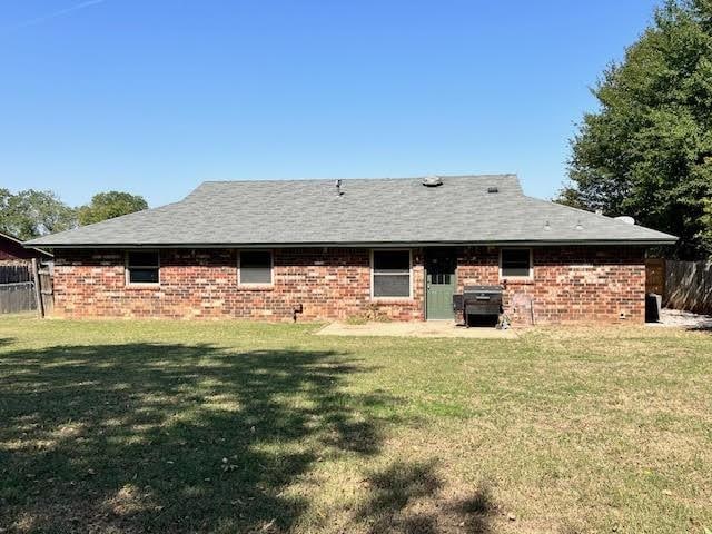 rear view of property featuring a lawn