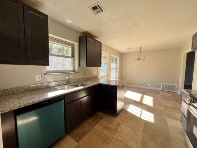 kitchen with sink, hanging light fixtures, stainless steel dishwasher, a notable chandelier, and kitchen peninsula