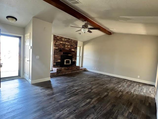 unfurnished living room with ceiling fan, dark hardwood / wood-style flooring, and lofted ceiling with beams