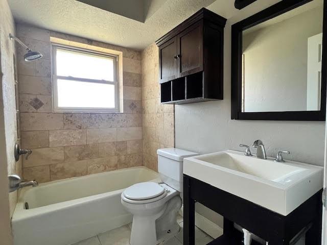 full bathroom with tile patterned flooring, tiled shower / bath combo, toilet, and vanity