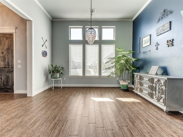 interior space with crown molding, hardwood / wood-style floors, and a chandelier