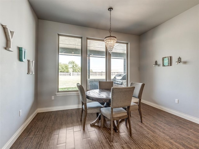 dining room with dark hardwood / wood-style floors and a notable chandelier