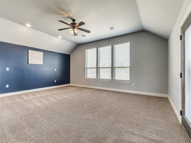 empty room featuring ceiling fan, carpet floors, and vaulted ceiling