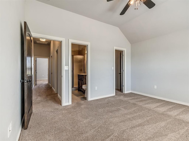 unfurnished bedroom with lofted ceiling, ensuite bath, ceiling fan, a spacious closet, and light colored carpet