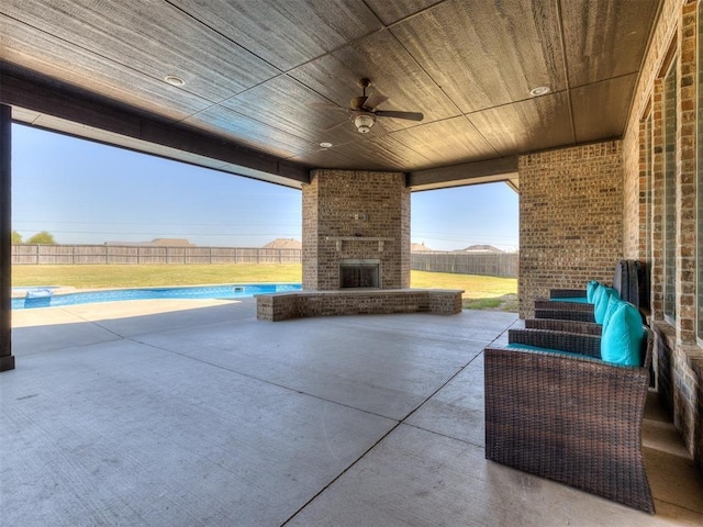 view of patio with ceiling fan and an outdoor brick fireplace