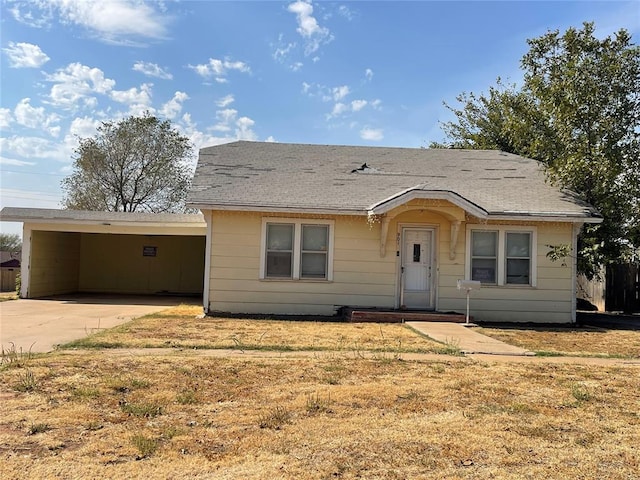 ranch-style home featuring a front lawn and a carport