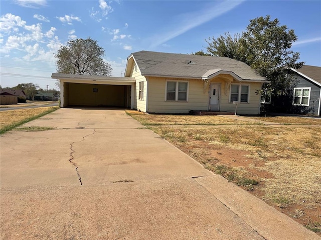 view of front of property with concrete driveway and a carport