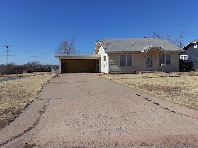 ranch-style house featuring a carport and driveway