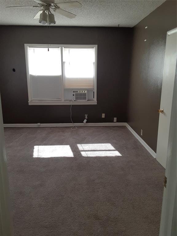 spare room featuring baseboards, a ceiling fan, a textured ceiling, cooling unit, and carpet floors