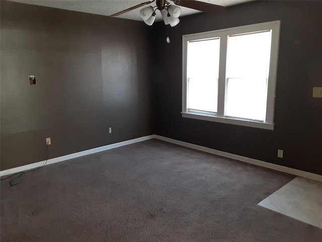 carpeted empty room with baseboards and a ceiling fan