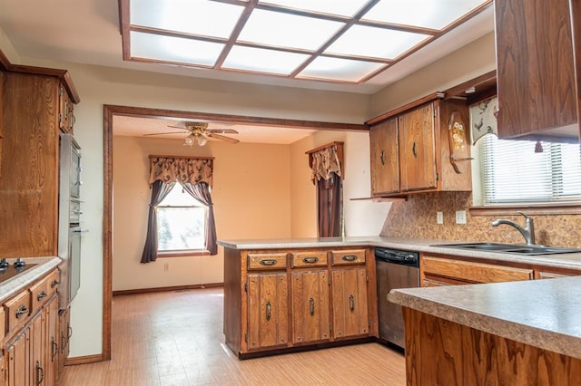 kitchen with ceiling fan, sink, kitchen peninsula, light hardwood / wood-style floors, and appliances with stainless steel finishes