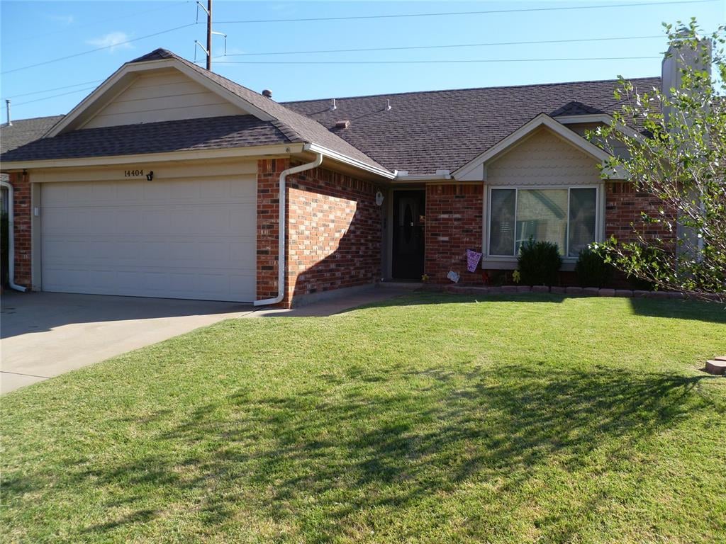 single story home with a front yard and a garage