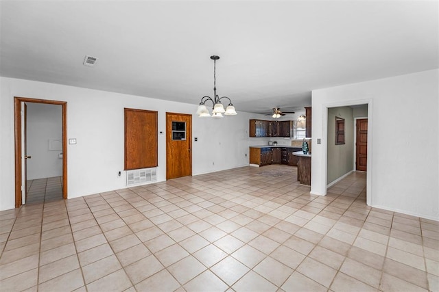 unfurnished living room with light tile patterned floors and ceiling fan with notable chandelier