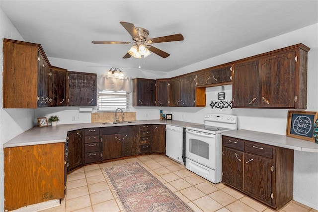 kitchen featuring dark brown cabinetry, white appliances, and sink