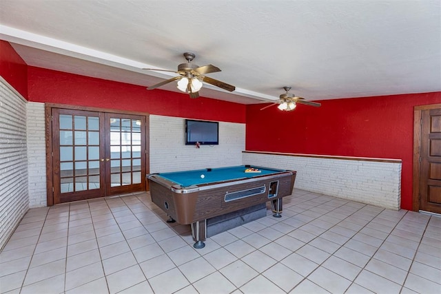 recreation room featuring french doors, light tile patterned flooring, brick wall, and pool table