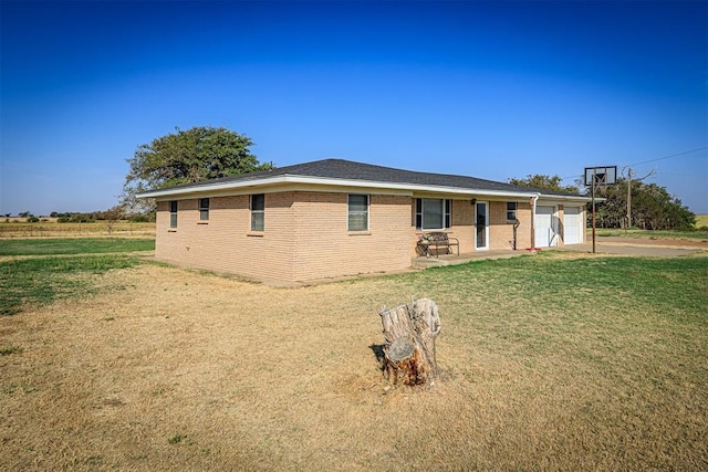 exterior space with a garage, a yard, brick siding, and concrete driveway