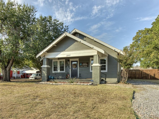 craftsman-style home featuring covered porch and a front lawn