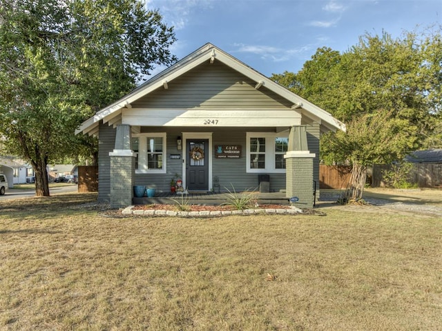 view of front facade featuring covered porch and a front yard