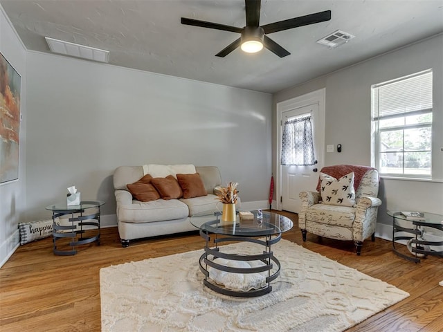 living room with wood-type flooring, plenty of natural light, and ceiling fan