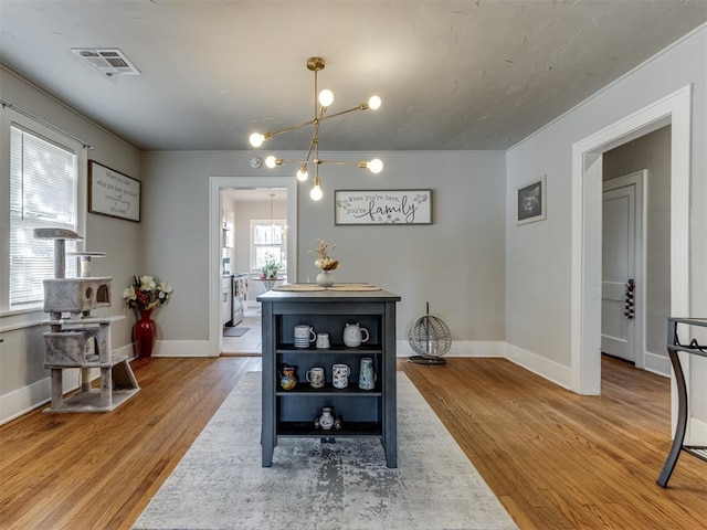 dining space featuring wood-type flooring and a notable chandelier