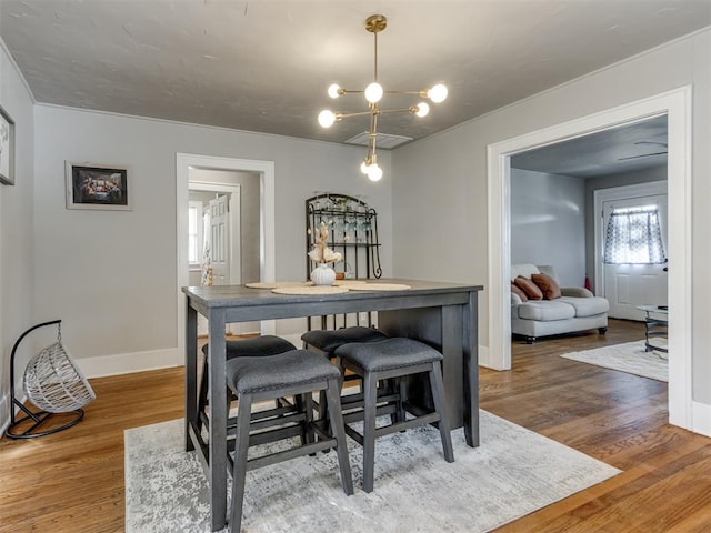 dining area featuring crown molding, hardwood / wood-style floors, and an inviting chandelier