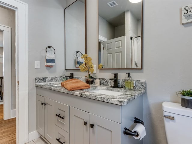 bathroom with hardwood / wood-style floors, vanity, and toilet